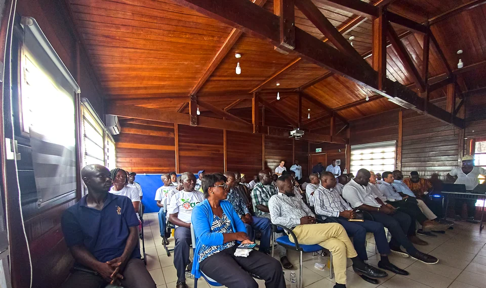 Rows of people seated in a wooden hall.